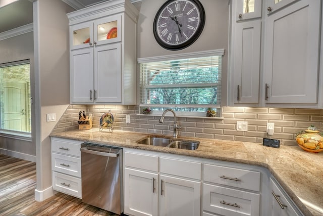 kitchen featuring glass insert cabinets, white cabinetry, a sink, and stainless steel dishwasher