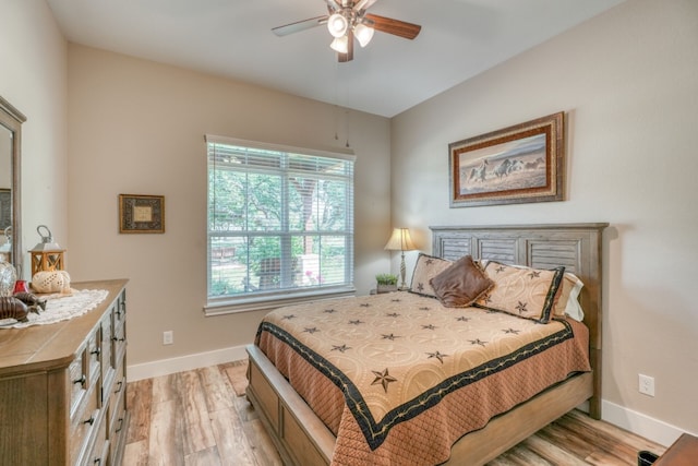 bedroom with light wood-style floors, baseboards, and a ceiling fan