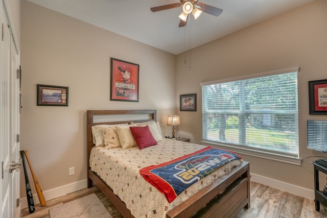 bedroom with a ceiling fan, baseboards, and light wood finished floors