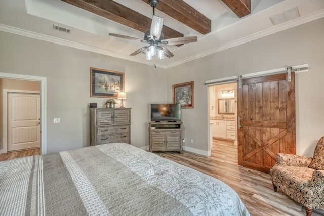 bedroom featuring light wood-type flooring, a barn door, visible vents, and beam ceiling