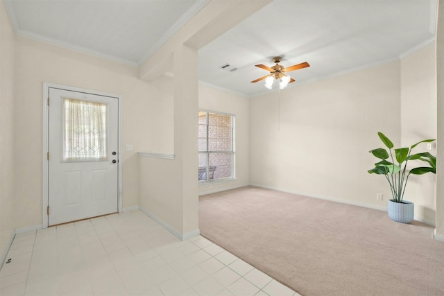 carpeted foyer with ceiling fan and crown molding