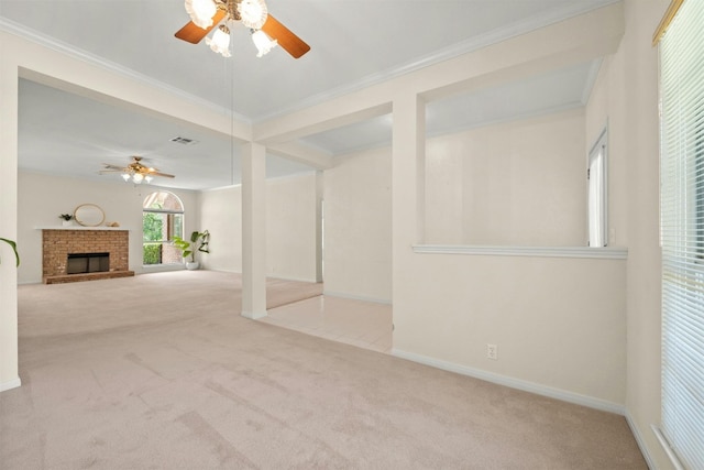 unfurnished living room with ceiling fan, light colored carpet, ornamental molding, and a brick fireplace