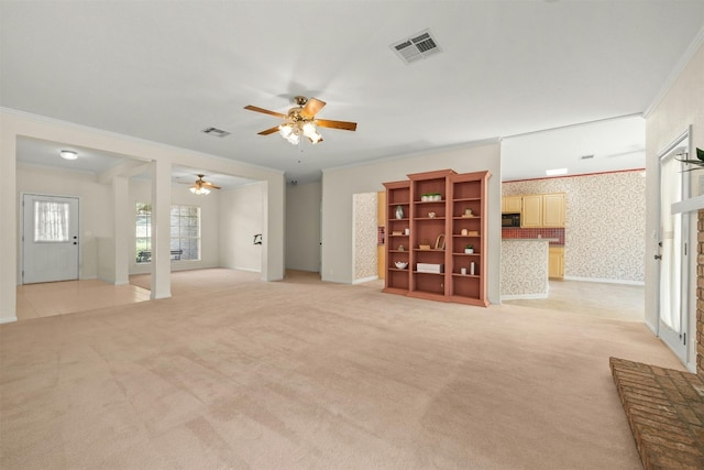 unfurnished living room with ceiling fan, crown molding, and light carpet