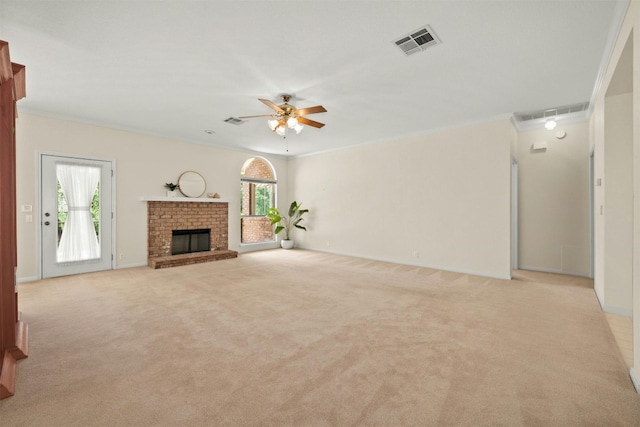 unfurnished living room with light colored carpet, ornamental molding, a wealth of natural light, and a brick fireplace