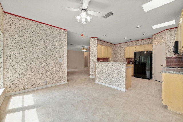 kitchen featuring a skylight, ceiling fan, and black fridge with ice dispenser