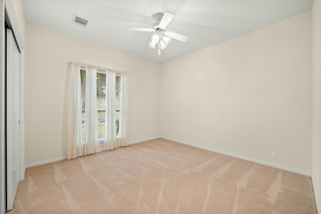 spare room with light colored carpet and ceiling fan