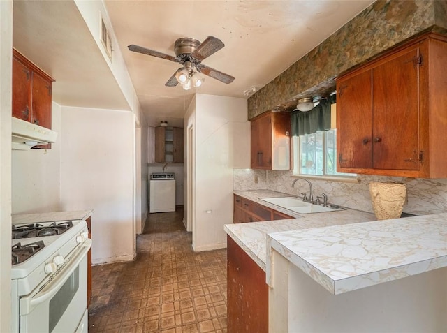 kitchen with decorative backsplash, ceiling fan, washer / dryer, sink, and white stove