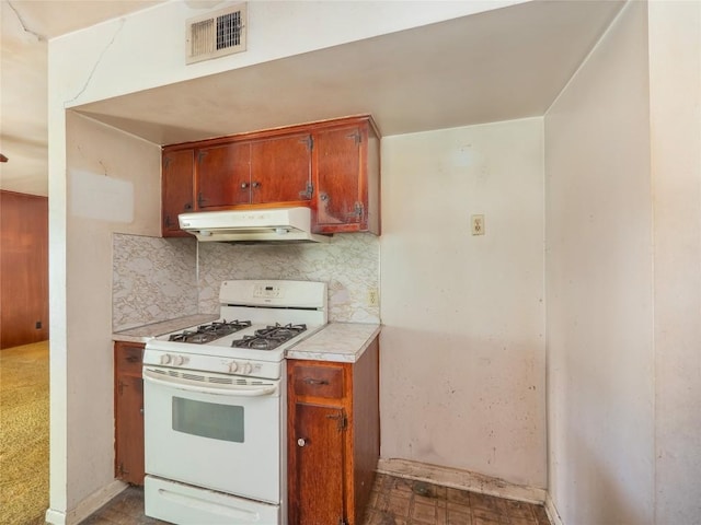 403AND401 Ramble Ln, Austin, TX 78745 - kitchen with white gas range, under cabinet range hood, decorative backsplash, and brown cabinets