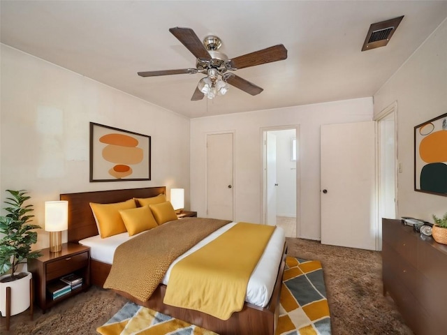 bedroom with a ceiling fan, dark colored carpet, and visible vents