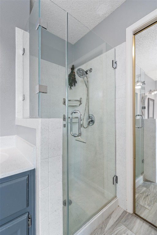 bathroom with an enclosed shower, vanity, and tile patterned floors