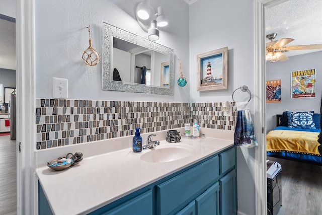 bathroom featuring backsplash, hardwood / wood-style flooring, a textured ceiling, vanity, and ceiling fan