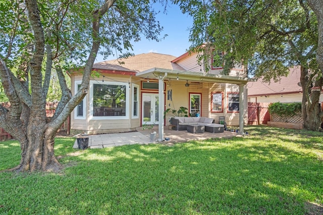 rear view of property with an outdoor living space, a patio area, and a lawn