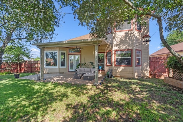 back of property with ceiling fan, a patio area, outdoor lounge area, and a yard