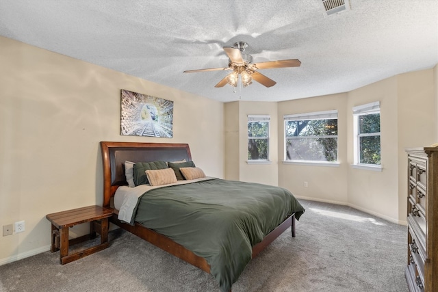 bedroom featuring ceiling fan, carpet, and a textured ceiling