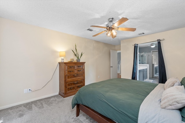 bedroom with a textured ceiling, carpet floors, ceiling fan, and connected bathroom