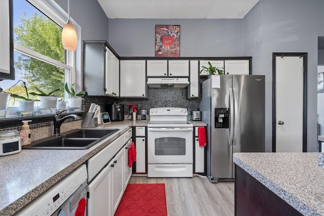 kitchen with white cabinetry, sink, white appliances, and decorative light fixtures