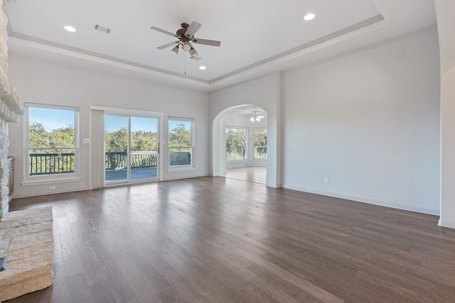 unfurnished room featuring ceiling fan, dark wood-type flooring, and a raised ceiling