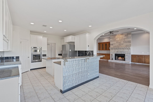 kitchen with white cabinetry, appliances with stainless steel finishes, a breakfast bar area, and light tile patterned flooring