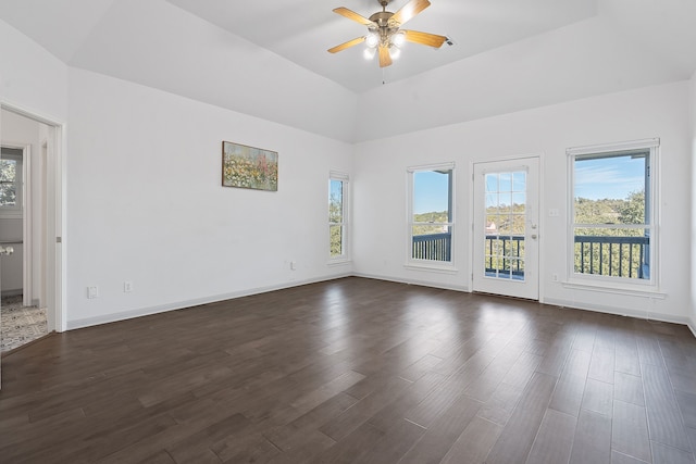 spare room with ceiling fan, dark hardwood / wood-style flooring, a raised ceiling, and a healthy amount of sunlight