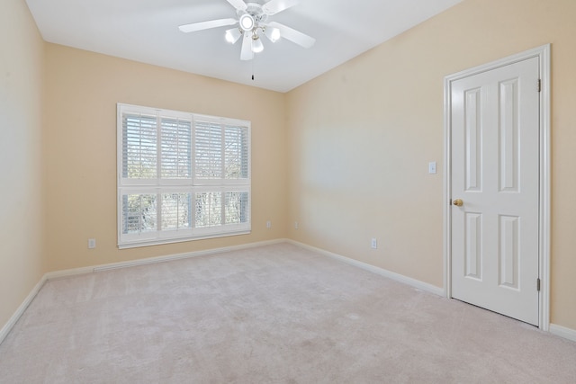 spare room with ceiling fan and light carpet