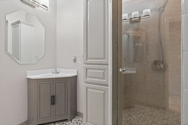 bathroom with a tile shower and vanity