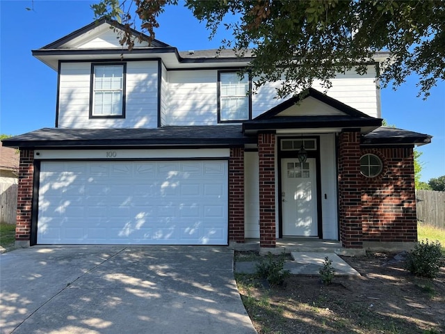 traditional-style house with a garage, concrete driveway, and brick siding