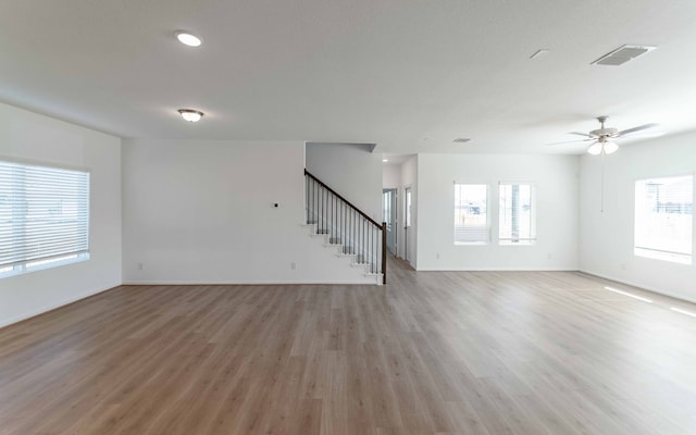 empty room with ceiling fan, light hardwood / wood-style flooring, and a wealth of natural light