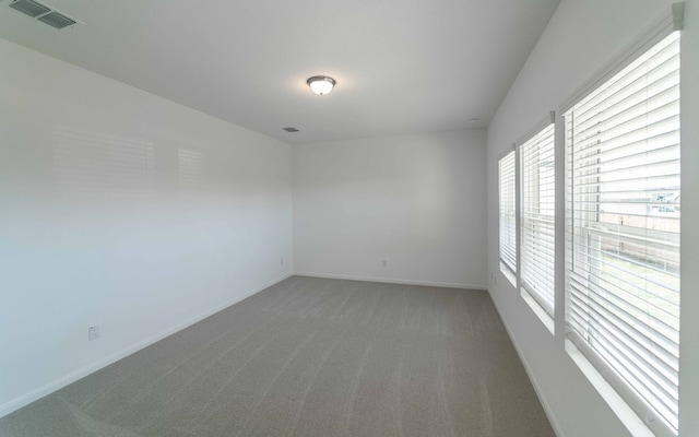 unfurnished room featuring dark carpet