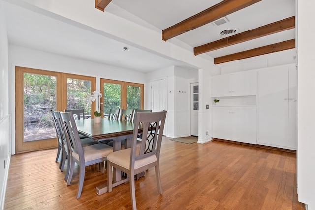 dining area with light wood-type flooring and beam ceiling