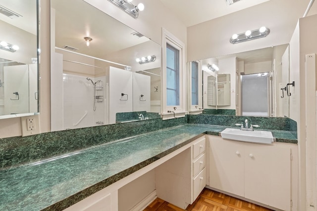 bathroom with walk in shower, vanity, and parquet floors