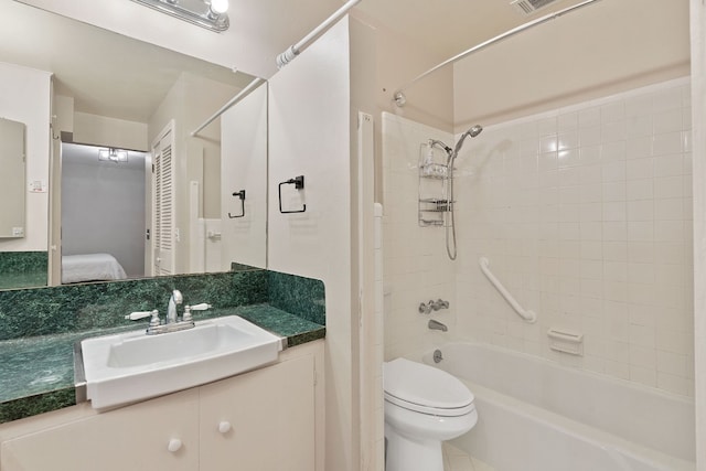 full bathroom featuring tiled shower / bath combo, vanity, and toilet