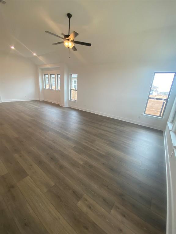 unfurnished room featuring ceiling fan, vaulted ceiling, and dark hardwood / wood-style flooring