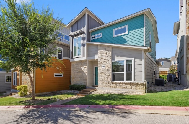 contemporary home with central air condition unit and a front yard