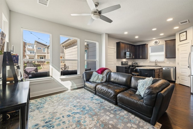 living room with ceiling fan, dark hardwood / wood-style floors, and sink