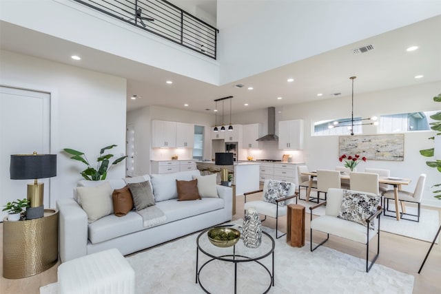 living room featuring a high ceiling and light hardwood / wood-style floors