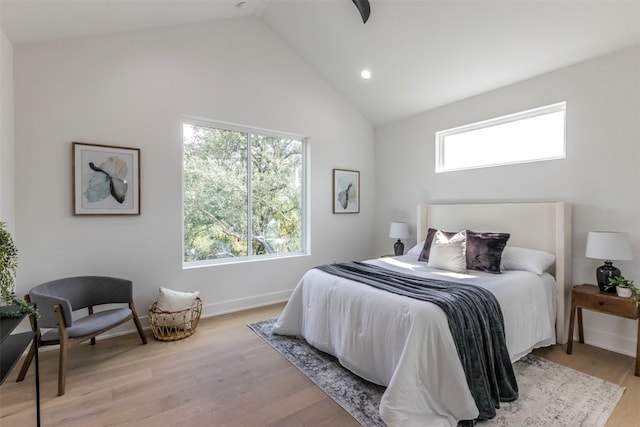 bedroom with high vaulted ceiling and light hardwood / wood-style floors