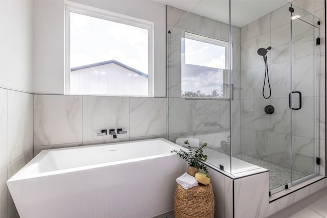 bathroom featuring tile walls, separate shower and tub, and tile patterned floors