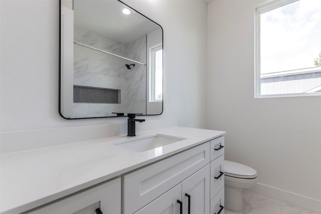 bathroom featuring tile patterned flooring, toilet, vanity, and a healthy amount of sunlight