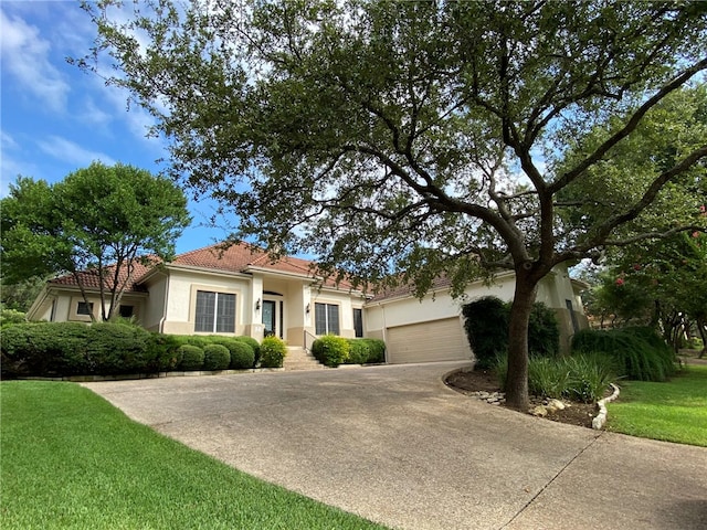 mediterranean / spanish-style house featuring a front yard and a garage