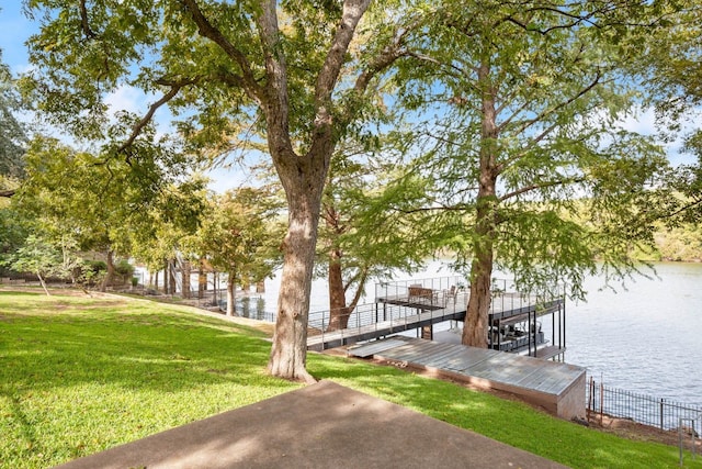 view of home's community featuring a lawn, a boat dock, and a water view