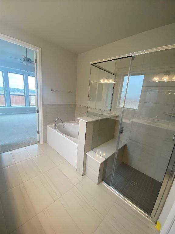 full bathroom featuring a garden tub, ceiling fan, tile patterned floors, and a stall shower