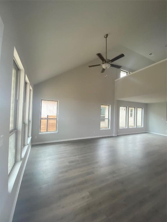 unfurnished room featuring dark hardwood / wood-style floors, ceiling fan, a healthy amount of sunlight, and high vaulted ceiling