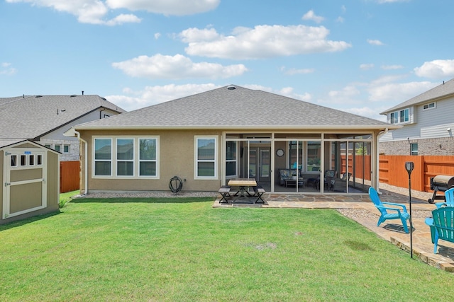 back of property with a patio area, a yard, and a storage shed