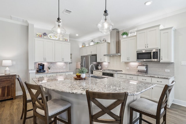 kitchen featuring wall chimney exhaust hood, stainless steel appliances, and decorative backsplash