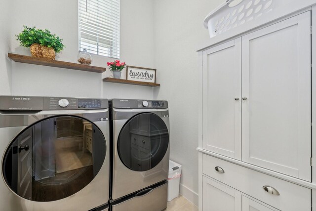 laundry room featuring cabinets and washer and clothes dryer