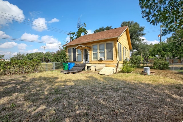 view of side of property featuring entry steps, a yard, fence, and a gate