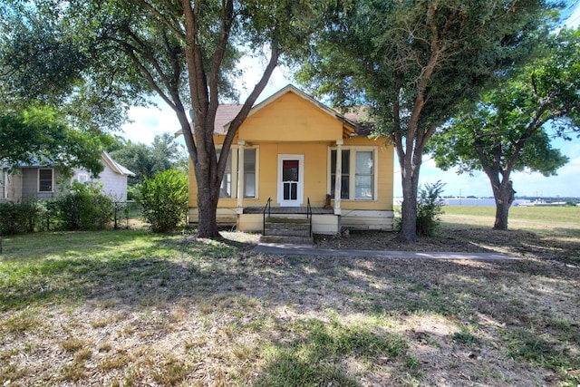 bungalow featuring covered porch and a front yard