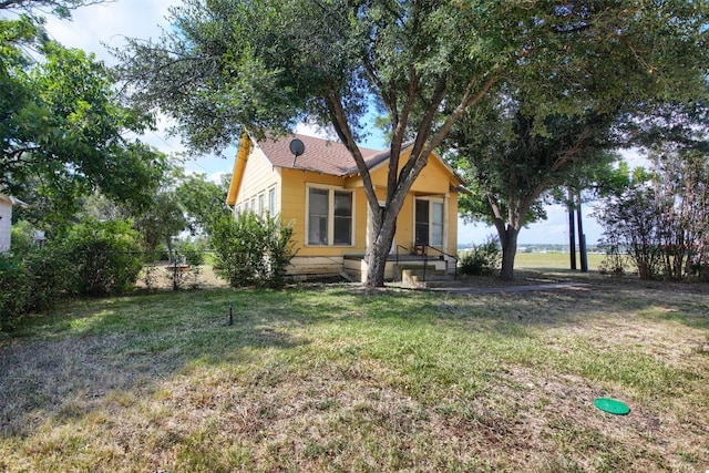 bungalow-style home with a front lawn and fence