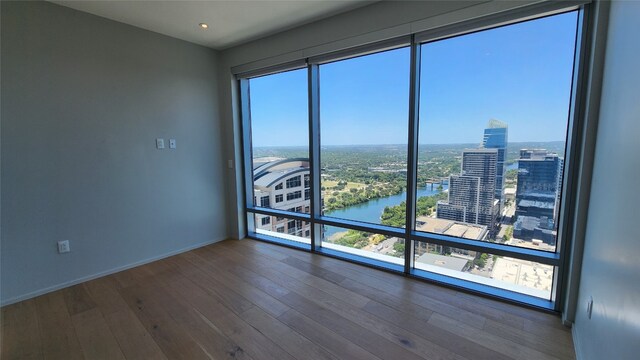 empty room featuring a water view and hardwood / wood-style flooring