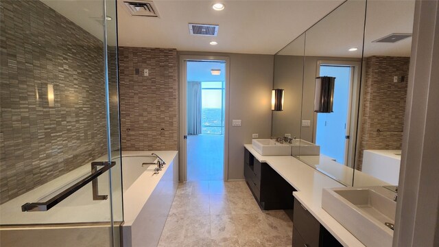 bathroom with double vanity, tile patterned flooring, and separate shower and tub